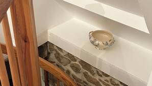 Un escalier en bois avec un mur de pierre en bas.