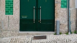 Une porte double verte sur laquelle on peut lire les mots « HAGAH » et « Alojamientos ».