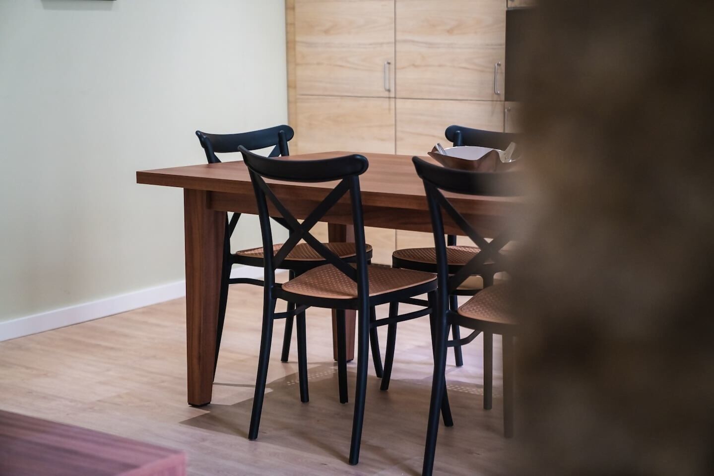 A dining area with a wooden table and four chairs.
