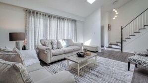 Een moderne woonkamer met een bank, salontafel en een rug met dessin.