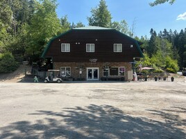 Un edificio rústico con fachada de piedra y techo verde, identificado como 'Canyon Store and Office'.