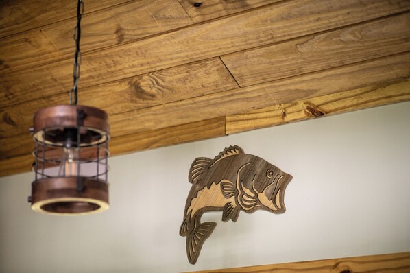 A wooden ceiling with a hanging light fixture and a wooden fish decoration. - Luxury Off-Grid Retreat - Lakeside Treehouse (Vincent)