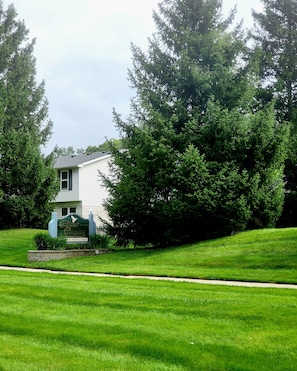 A residential house with a well-maintained lawn and a sign indicating it is part of a condominium community.