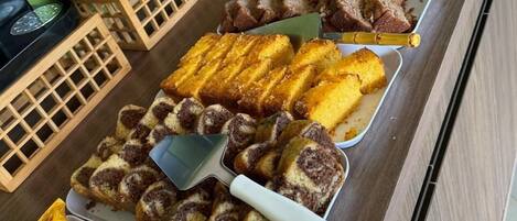 Un bufé con distintos alimentos, como pan, bollería y aperitivos.