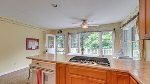 A kitchen with a large island, wooden cabinets, a gas stove, and a ceiling fan. - Fish, Hike & Unwind: Remote Home in Ararat! (Ararat)