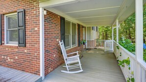 A covered porch with a brick wall, white railing, and a rocking chair. - Fish, Hike & Unwind: Remote Home in Ararat! (Ararat)