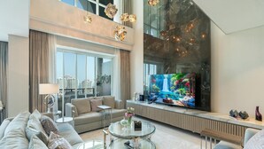 Una sala de estar moderna con un televisor de pantalla plana grande, asientos cómodos y una mesa de centro de vidrio.