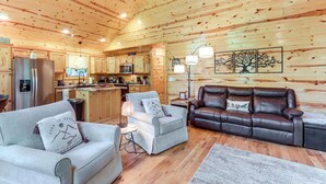 A cozy cabin interior with a living room, a dining area, and a kitchen. - 10 Mi to Main St Murphy: Cabin w/ Covered Deck! (Murphy)