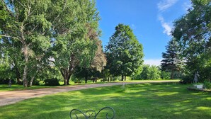 A park with a gravel path, benches, and a wooden fence.