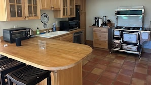 Una cocina con armarios de madera, microondas integrado, estufa y lavaplatos.