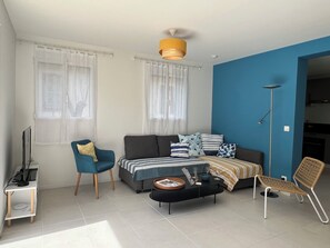 A modern living room with a sofa, armchair, coffee table, and a floor lamp.