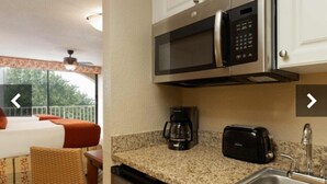 Una kitchenette con microonde, tostapane e macchina del caffè.