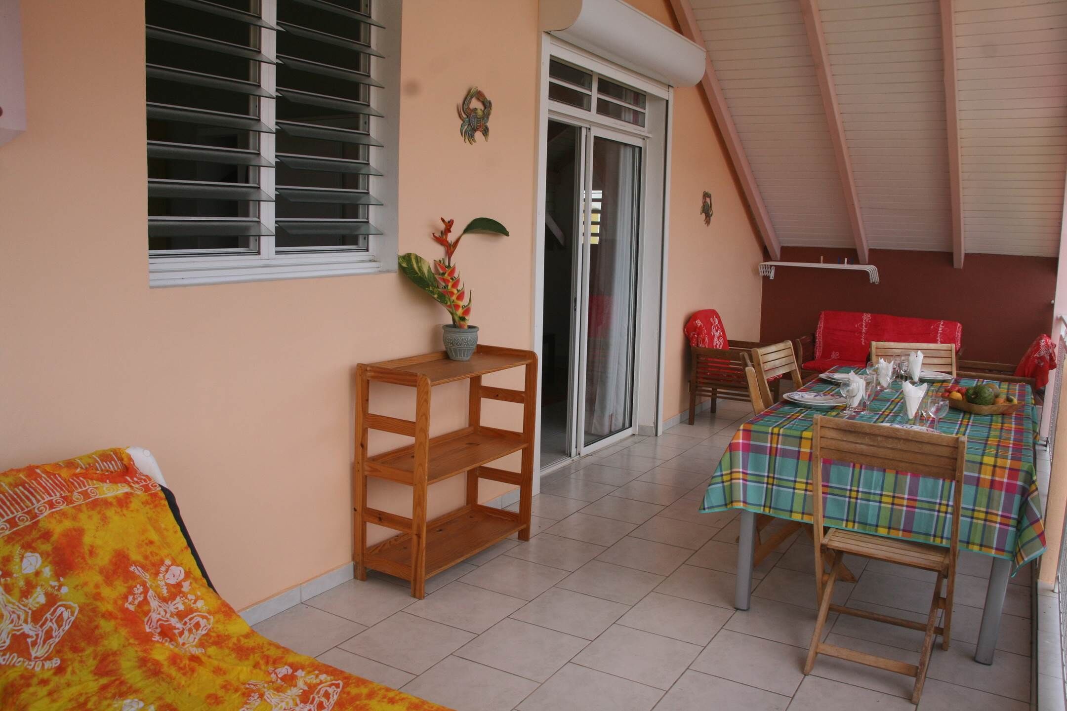 A dining area with a table set for four, a wooden chair, and a window with blinds.
