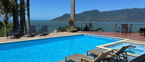 Una piscina al aire libre, sombrillas, tumbonas