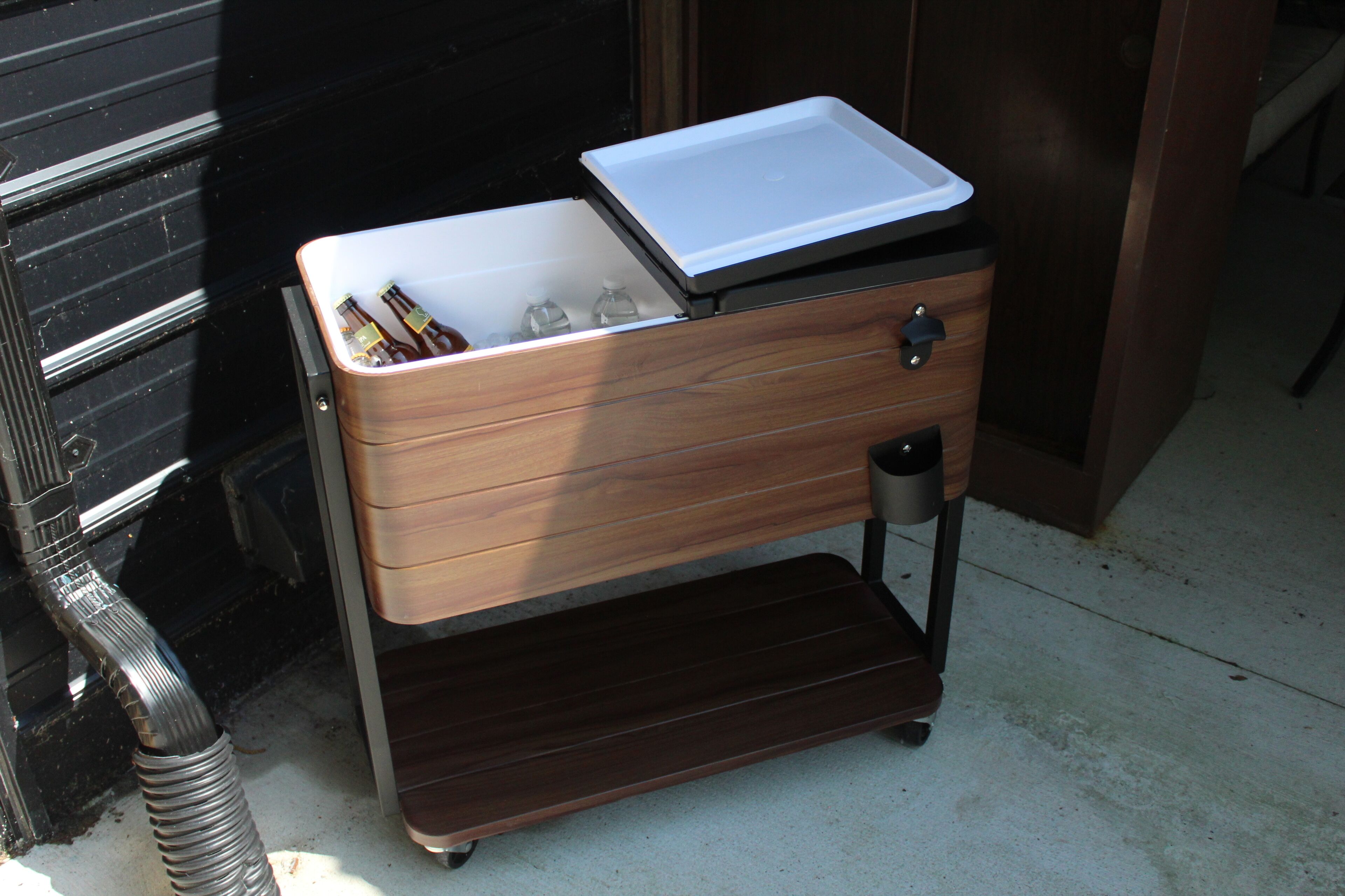 Ein Holzschrank mit Schublade und Ablagefläche, der Flaschen und Gläser beherbergt.
