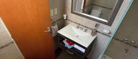 A bathroom with a toilet, bidet, sink, and bathtub.