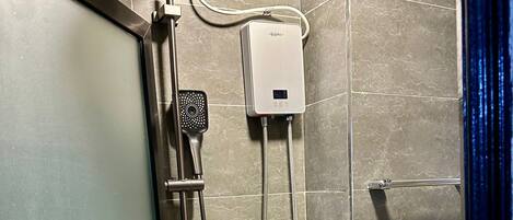 A shower with a handheld showerhead, a fixed showerhead, and a control panel.