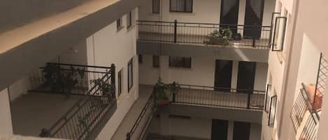 A multi-level building with balconies, railings, and a covered outdoor area.