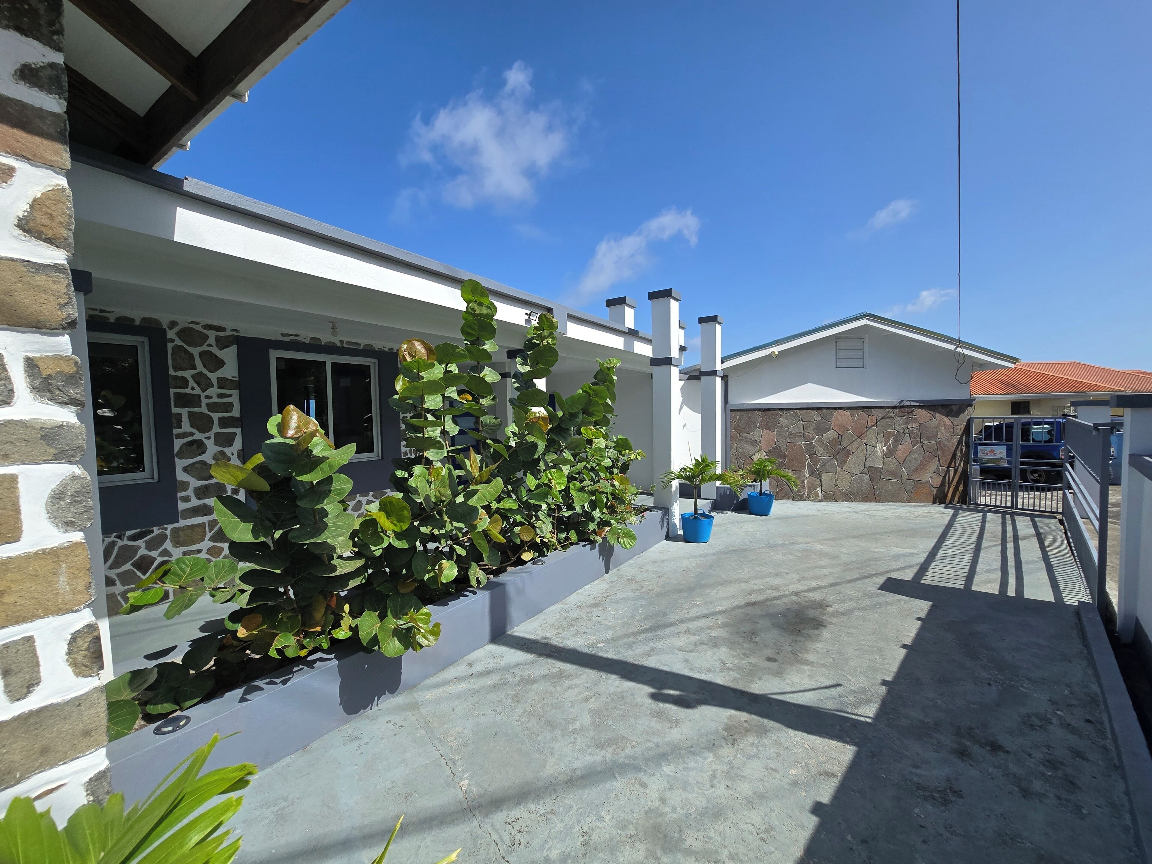 A modern house with a stone facade, a concrete driveway, and a garage.