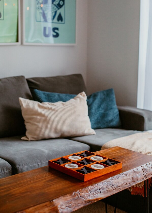 A living room with a grey sofa, a wooden coffee table, and a framed picture on the wall.