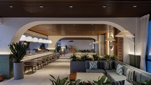 A modern lounge area with a long counter, seating, and plants. - Doubletree By Hilton Tashkent (Tashkent)