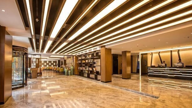 Un vestíbul ampli amb un paviment de marbre brillant, una taquilla d'informació i prestatgeries de llibres.