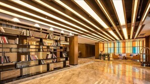 Un vestíbul modern amb sòl de marbre, prestatgeries de llibres i una zona d'estar amb sofàs.