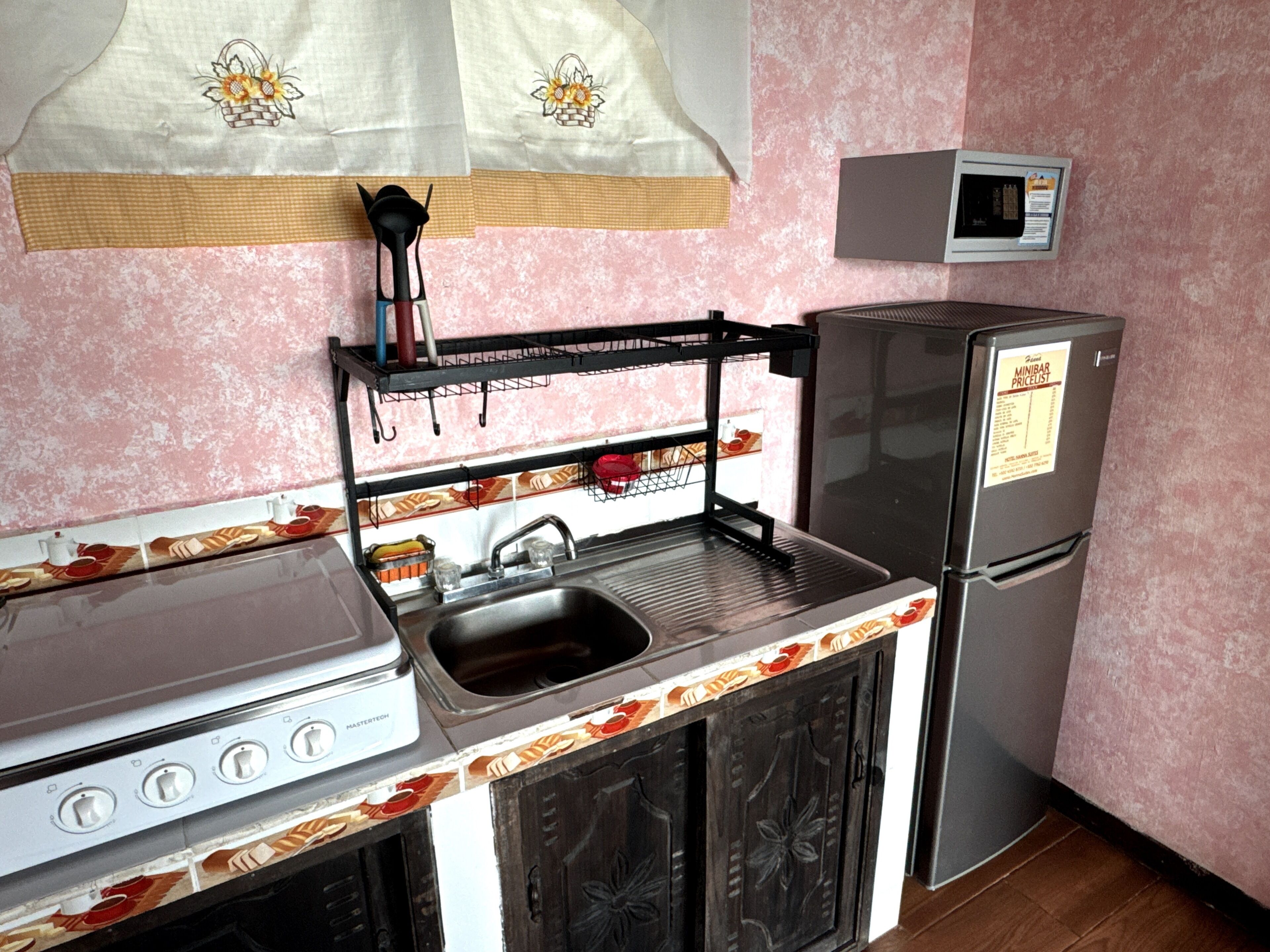 A compact kitchen with a gas stove, sink, and a refrigerator.