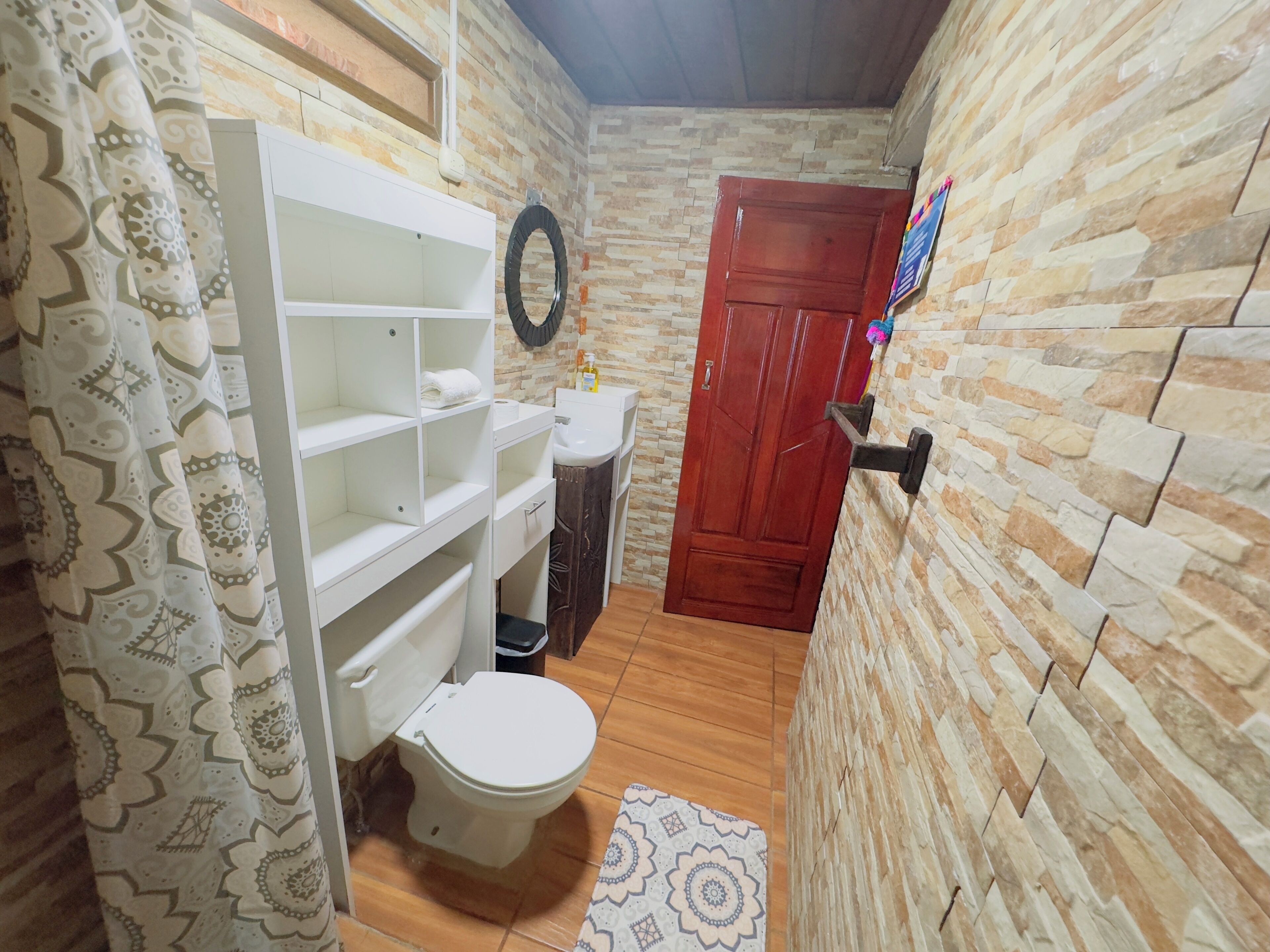 Un bagno con il water, un lavabo e degli scaffali.