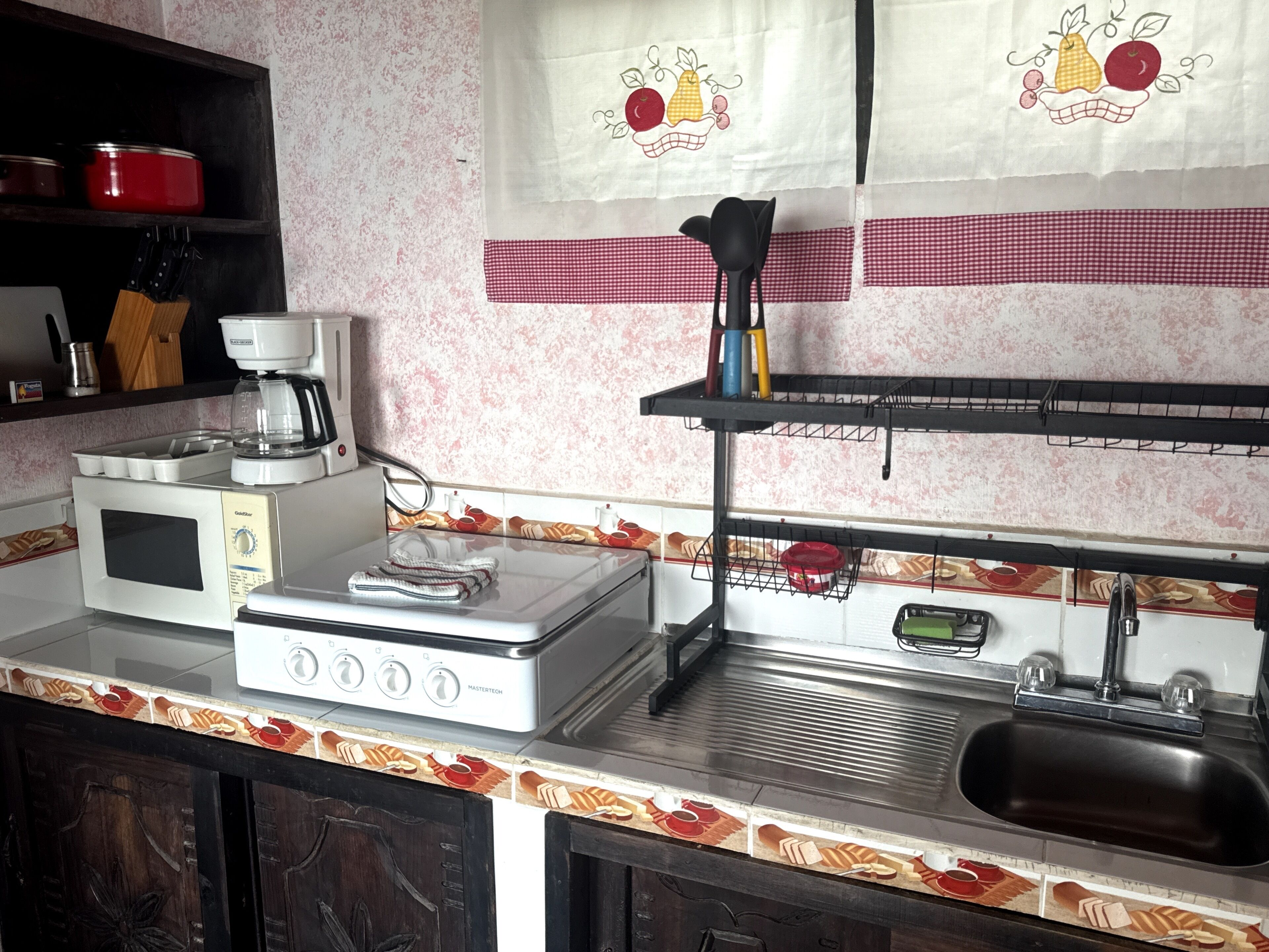 A kitchen with a microwave, stove, and sink.