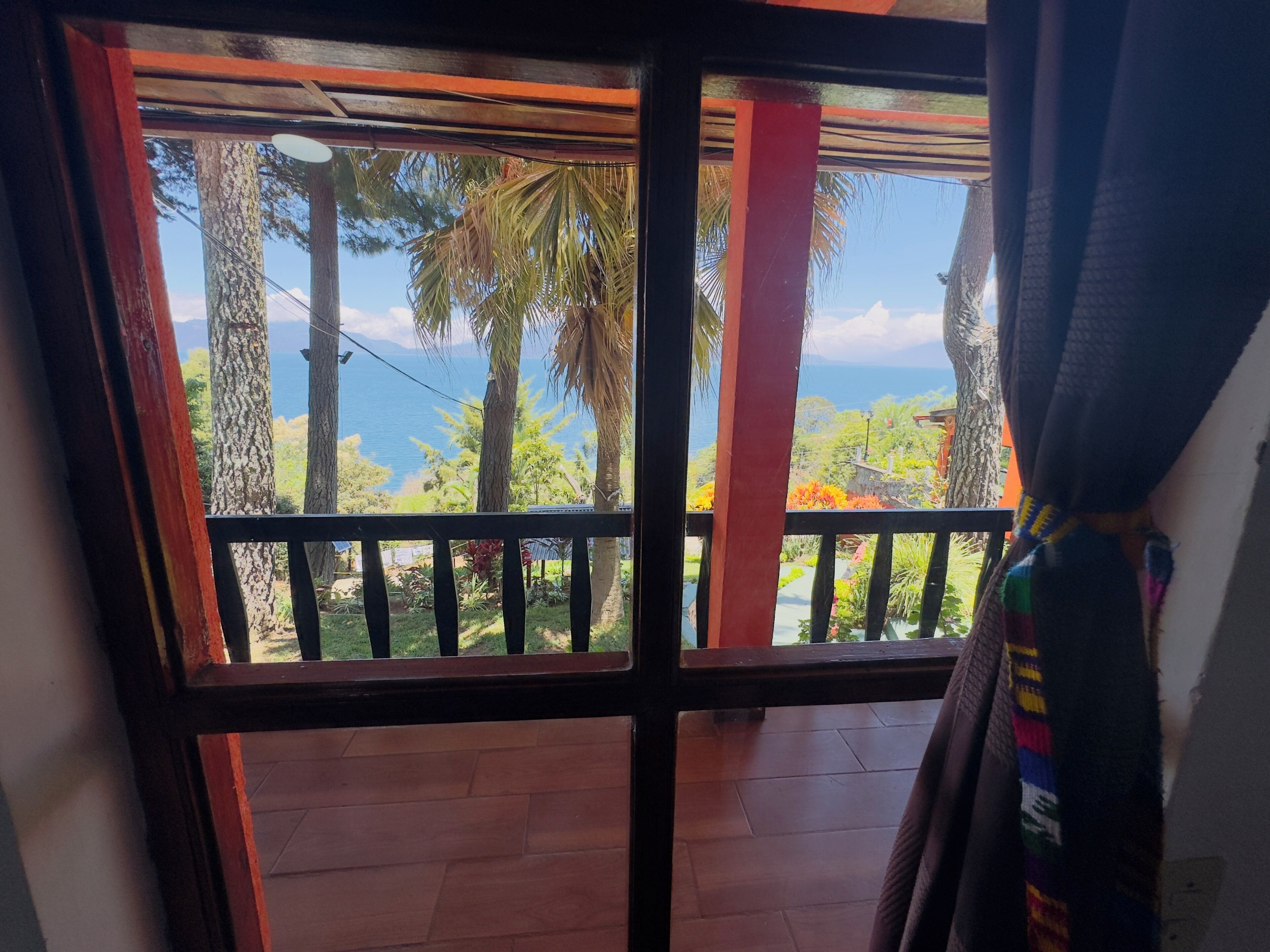 A balcony with a view of a mountainous landscape and a body of water.
