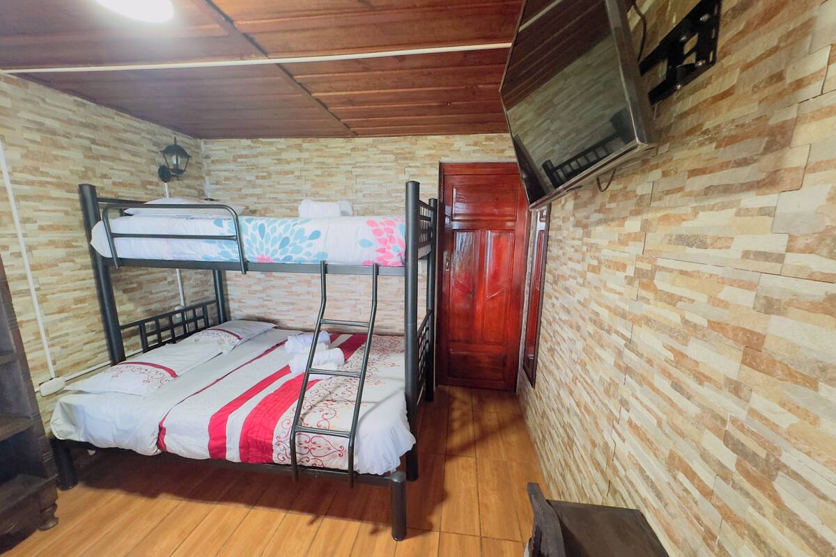 A bunk bed with a wooden floor, a brick-patterned wall, and a wooden cabinet.