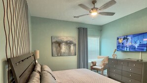 A bedroom with a bed, a ceiling fan, a TV, a dresser, a chair, and a window with curtains. - NEW Putt Chip&Chill 3BRTownhouse NMB SportsComplex (little river)