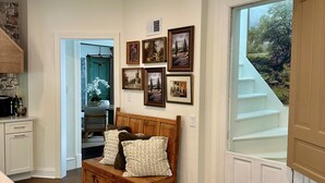 Un dormitorio con una cama de madera, una mesita de noche y un aparador. Hay cuadros enmarcados en la pared y una ventana con vistas al exterior.