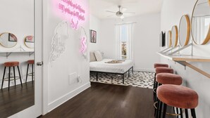 A modern bedroom with a bed, a ceiling fan, and a bar area with stools. - Charming 1-Bedroom Condo, 10 Minutes From Downtown Nashville (Nashville)