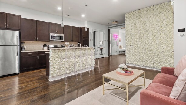 A modern kitchen with dark wooden cabinets, stainless steel appliances, and a central island with a white floral backsplash. - Charming 1-Bedroom Condo, 10 Minutes From Downtown Nashville (Nashville)