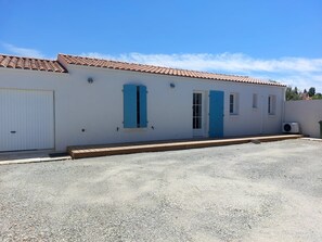 A single-story building with a tiled roof, a white exterior, and a gravel driveway. - Regarding a WITHDRAWN LISTING: BEAUTIFUL 3-STAR-RATED HOUSE IN LA COTINIERE (Saint-Pierre D Oleron)