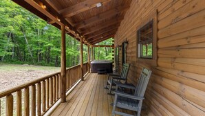 A wooden cabin with a porch, a hot tub, and outdoor seating. - Trails End- Sauna, Hot Tub, Fire pit, Arcade, King Beds, Luxury stay, less than 8 miles to all attractions/hikes (Logan)