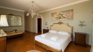 Un dormitorio elegantemente decorado con una cama grande, una araña, un espejo y un cuadro en la pared.