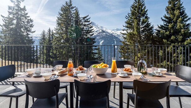 A dining table set outdoors with a mountain view, surrounded by chairs. - Holiday Home in La Rosiere Near Ski Slopes (Montvalezan)