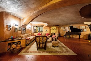 Un salón amplio con un piano de cola, asientos cómodos y un tapete decorativo.