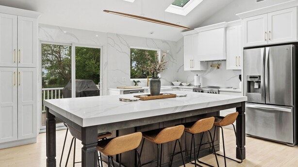 A modern kitchen with white cabinetry, a marble countertop, a stainless steel refrigerator, and a skylight. - Beautiful and Spacious  Home with WiFi and AC in delightful Narragansett (Narragansett)