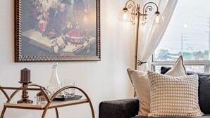 Un salon moderne avec un canapé foncé, une table basse décorative en métal et un tableau encadré accroché au mur.