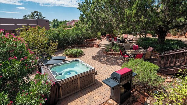 A backyard with a hot tub, outdoor seating, and a barbecue grill. - Charming 3-bedroom house with WiFi, fitness/gameroom in Sedona! Serene Backyard! (Sedona)