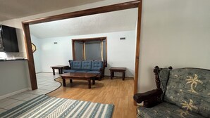 Un salon avec un canapé, une table basse et un tapis à motifs.