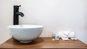 A white ceramic sink with a black faucet on a wooden countertop. - VH  Loft moderno en Cibeles Roma Norte  169 (Ciudad de México)
