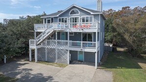 A two-story house with a balcony, a garage, and a well-maintained lawn.