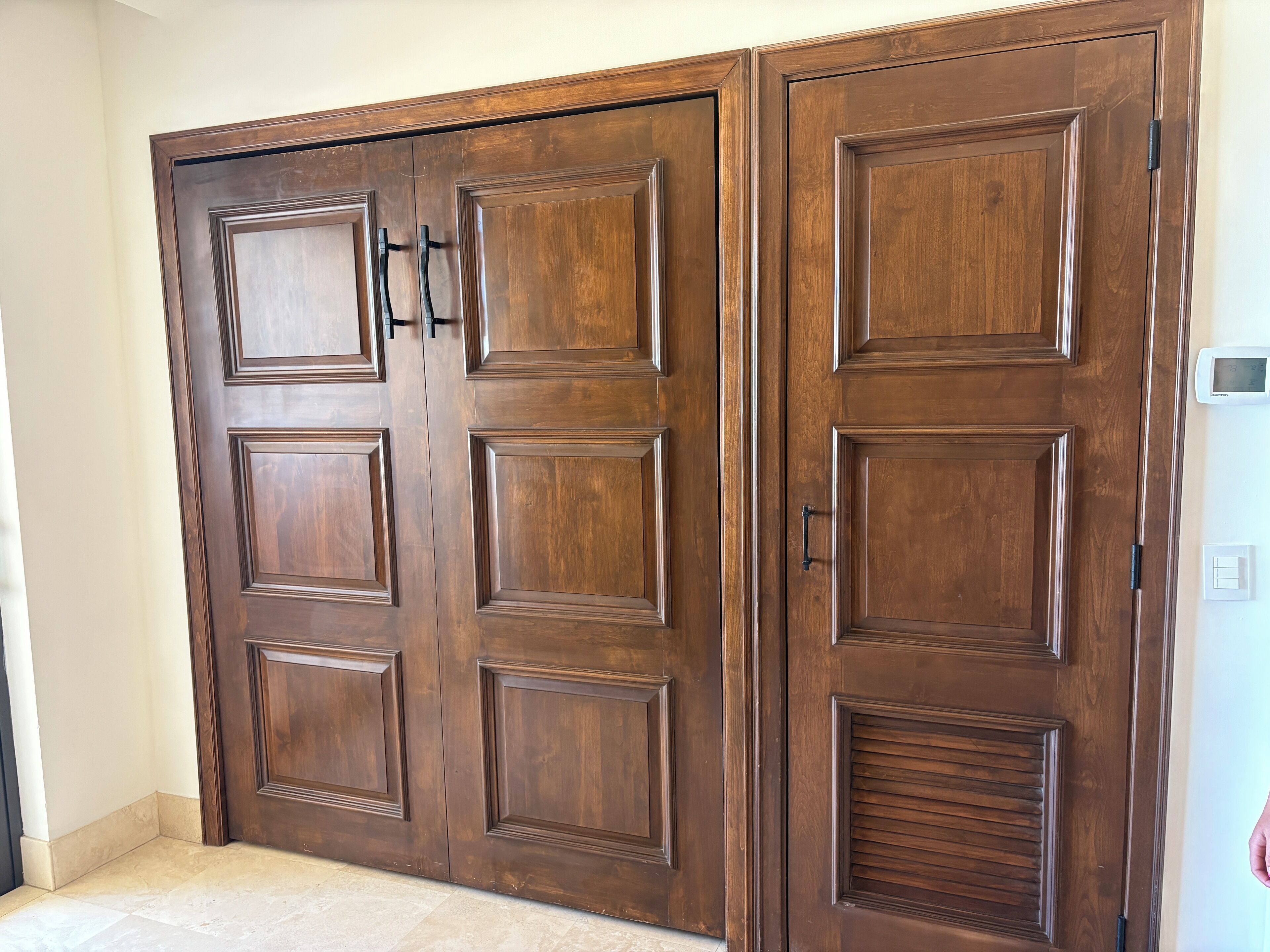 A large, dark wooden wardrobe with multiple doors and handles.