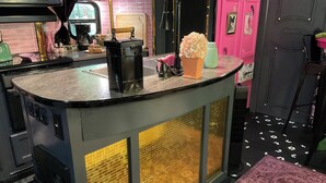 Una cocina con mostrador, cafetera y ventana.