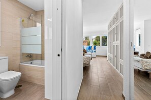 A modern bathroom with a shower, toilet, and bathtub.
